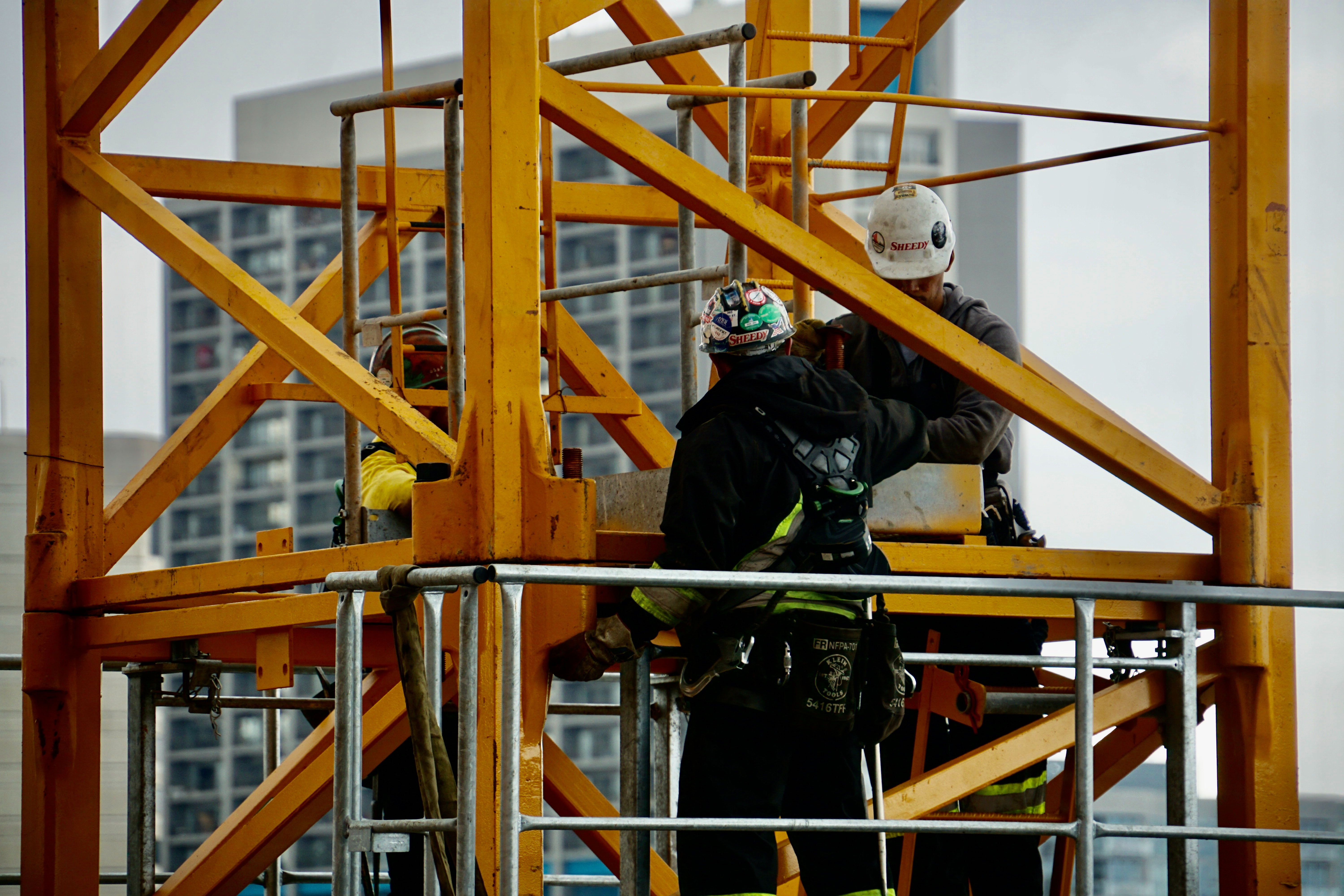 Three contruction workers operating with a crane